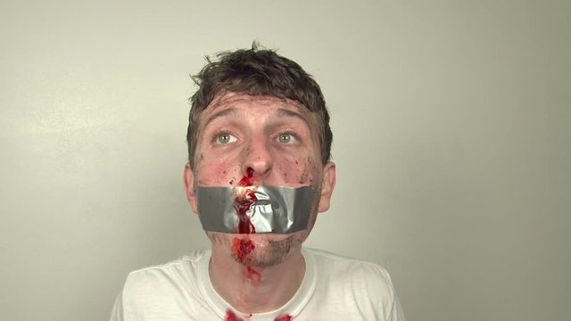Man with duct tape covered mouth calling for help.
