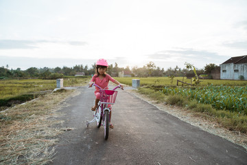 toddler enjoy riding her bicycle outdoor in beautiful day