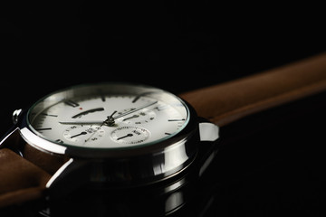close up of wristwatch on black background