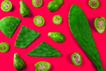Cactus leaves and cactus fruits - tuna on pink background. Creative layout. Top view