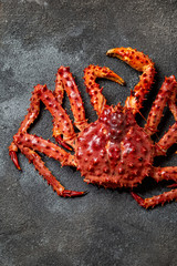 Red king crab on gray background. King crab, lemon and cilantro, top view