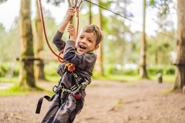 Little boy in a rope park. Active physical recreation of the child in the fresh air in the park....