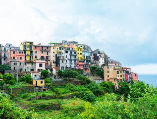 Fototapeta premium View of the houses and nature of Corniglia, one of the Cinque Terre villages in Liguria, Italy. Mediterranean sea and green mountains.
