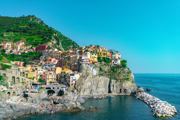 Fototapeta na wymiar Amazing view of Manarola village in Cinque Terre, Italy. Sunny day and blue sky of an afternoon in the European summer. Unesco World Heritage Site