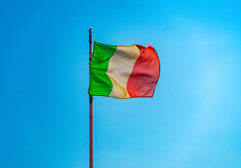 Italian flag on a sunny day with blue sky during the European summer. Flag of Italy country.