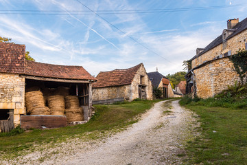 Gravel road passing through old French farmhouses