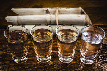 Cachaça, drip, cane or sugarcane is the name given to sugarcane brandy produced in Brazil. Traditional alcoholic drink from Brazil with sugar cane in the background.