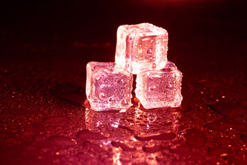 ice cubes on a reflections red light.