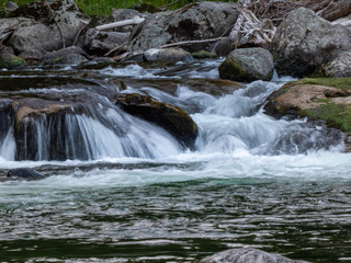 Fototapeta na wymiar fresh clean water running over rocks creating small waterfalls