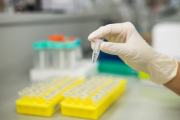 laboratory equipment pipette dropping sample into a test tube,abstract science background.
