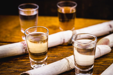 Two glasses of Brazilian gold and white cachaça isolated on rustic wooden background. Typical alcoholic drink from Brazil.