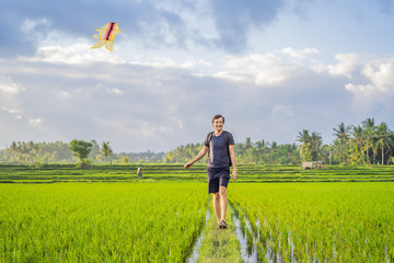 Man launch a kite in a rice field in Ubud, Bali Island, Indonesia