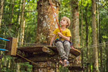 Little boy in a rope park. Active physical recreation of the child in the fresh air in the park....