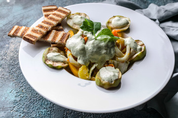 Close-Up Squid salad, with grilled zucchini vegetables, tomatoes, carrots, arugula sauce and croutons. Delicious healthy low-calorie salad
