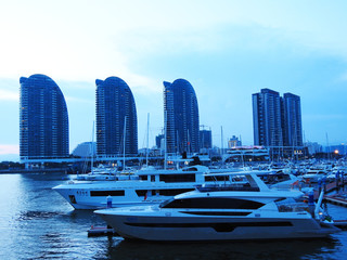 Obraz premium Hainan, Sanya, China-July 20, 2019. Evening pier. Boats. Yachts. Water infrastructure. 