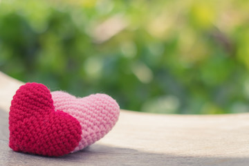 Red and pink hearts on wooden swing with beautiful blurred background