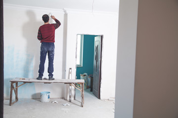 Man painting wall with white color. Renovation