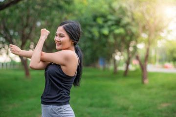 Young attractive Asian woman warm up before running at the park in the morning. Healthy and lifestyle sport with nature concept.