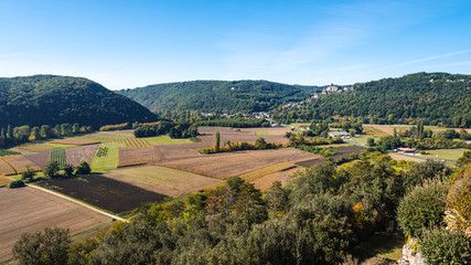 Fototapeta na wymiar View over farms in the Dordogne valley towards the medieval chateau of Castelnaud-la-Chapelle