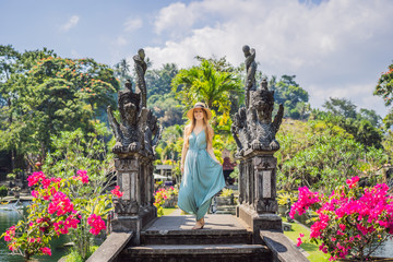 Young woman tourist in Taman Tirtagangga, Water palace, Water park, Bali Indonesia - obrazy, fototapety, plakaty