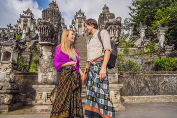 Naklejka premium Happy couple of tourists on background of Three stone ladders in beautiful Pura Lempuyang Luhur temple. Summer landscape with stairs to temple. Paduraksa portals marking entrance to middle sanctum