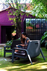 Fototapeta premium Woman reading a book on a tropical garden