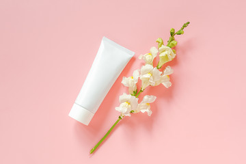 White flowers and cosmetic, medical white tube for cream, ointment, toothpaste or other product on...