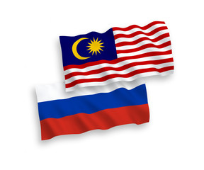 National vector fabric wave flags of Malaysia and Russia isolated on white background. 1 to 2 proportion.