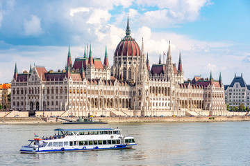 Fototapeta na wymiar Das parlamentsgebäude in Budapest, der Hauptstadt Ungarns, mit einem Ausflugsboot im Vordergrund auf der Donau