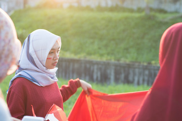 portrait of young asian muslim woman group preparing prepare flags to decorate