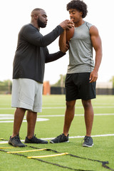 American Football coach training a young athlete.