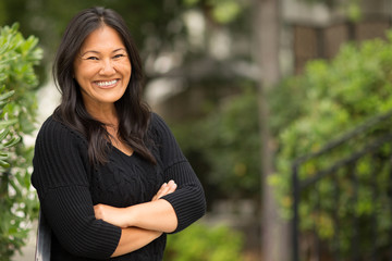 Portrait of an Asian woman sitting outside.