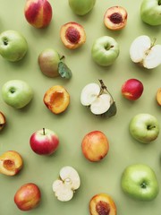 green apples and peaches on a green background flat layout top view. Fruits pattern. 