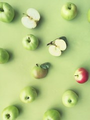 green apples on a green background flat layout top view. Fruits pattern. 