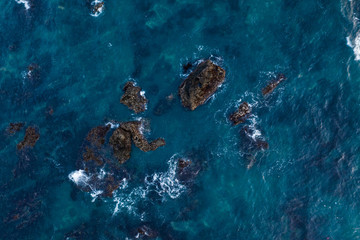 Obraz na płótnie Canvas Aerial drone top view of the crystal clear lagoon sea water surface with coral reef and rocks
