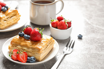 Fresh delicious puff pastry with sweet berries on grey marble table. Space for text