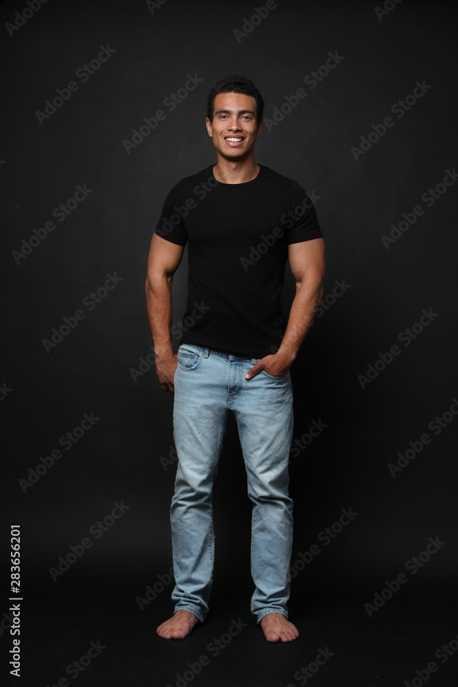 Wall mural Handsome young African-American man on black background