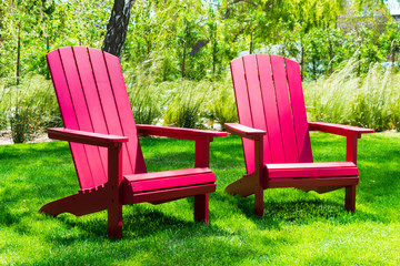 Traditional curveback sunset red plastic outdoor patio adirondack chairs with contoured backs and...