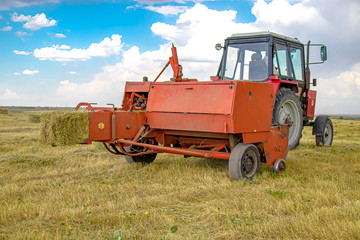 Grass collection by pick-up for livestock feed. Rural landscape