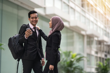 Two asian business partner wear a suit of blazer smiling to each other