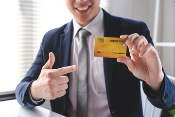 Male employees are pointing fingers preferred credit card. Business, finance and online shopping concept.