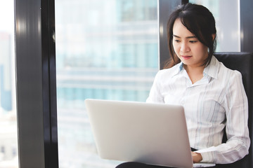 Asian businesswoman working with laptop computer at the work place.