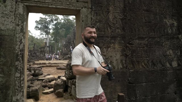 Man sightseeing ancient Angkor Wat temple ruins in Cambodia