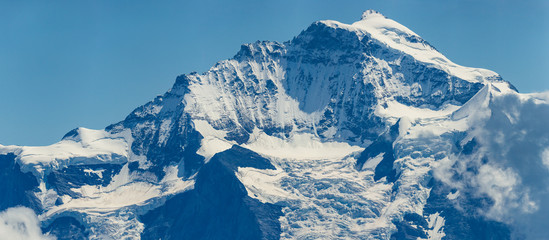 summit of Jungfrau mountain with glaciers and blue sky
