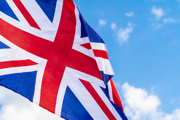 Fototapeta na wymiar United Kingdom Flag waving on wind in blue sky