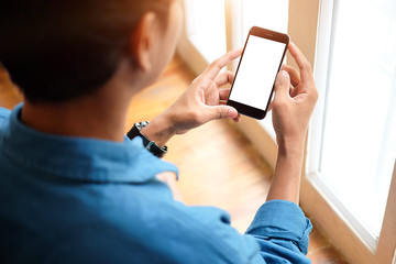Cropped shot view of man hands holding smart phone with blank copy space screen for your text message or information content, female reading text message on cell telephone during in urban setting. 