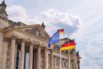 The Reichstag in Berlin with the German flag, the EU flag and the inscription  The German people