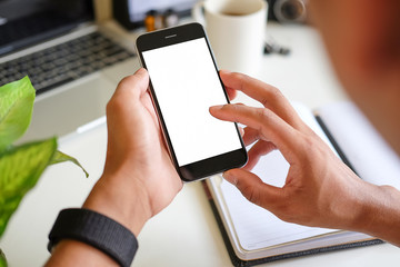 Cropped shot view of man hands holding smart phone with blank copy space screen for your text message or information content, female reading text message on cell telephone during in urban setting. 