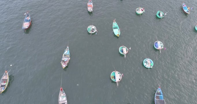 Top view, aerial view fishing harbor market from a drone. Royalty high-quality free stock video footage of market at Mui Ne fishing harbour or fishing village. Fishing harbor is a popular tourist 