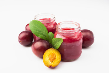 Violet fresh ripe plums and a glass with a puree from plums